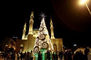 Lebanese people gather around a Christmas tree decorated at Martyrs' Square near the Mohammed al-Amin mosque in downtown Beirut on December 23, 2012. AFP PHOTO/ANWAR AMRO
